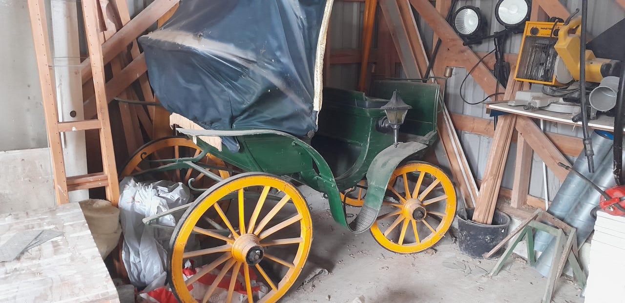 Vihreä hevoskärry katoksella ja lyhdyillä