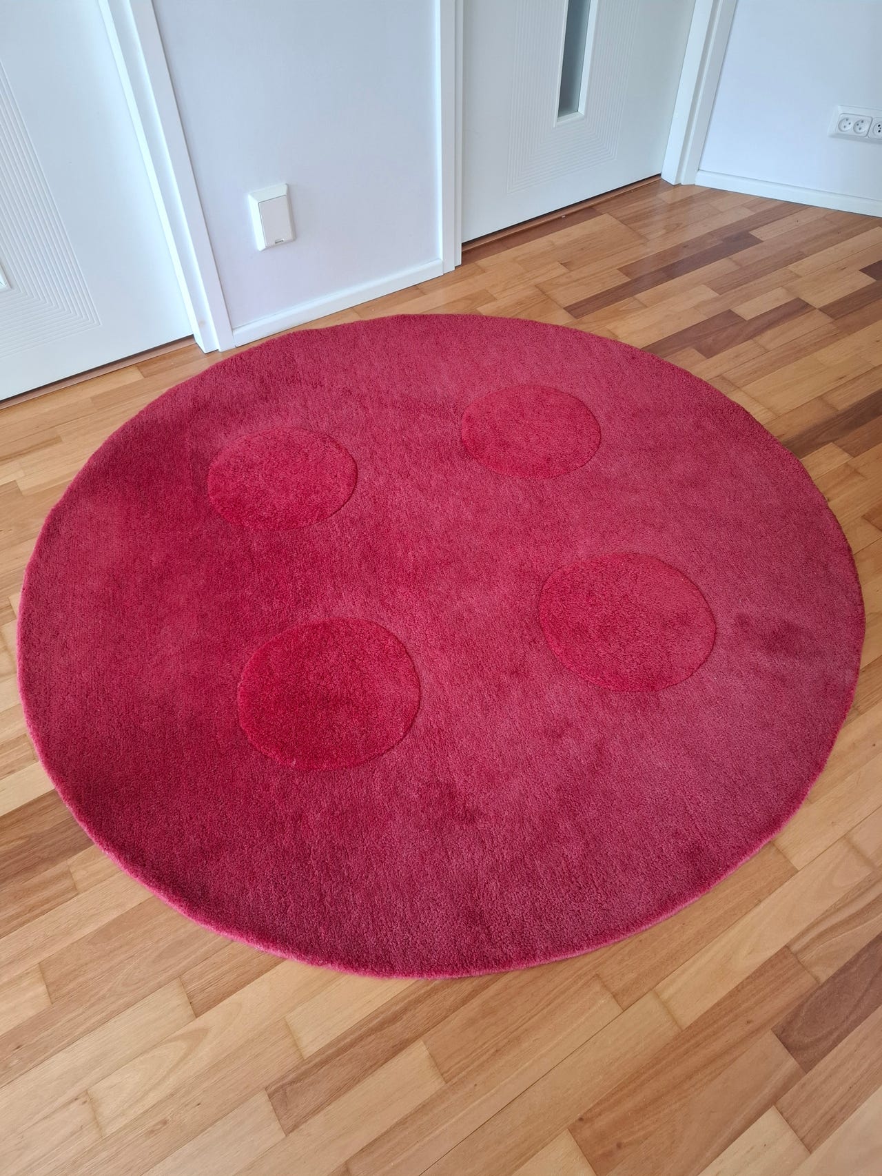Punainen pyöreä matto pallokuviolla