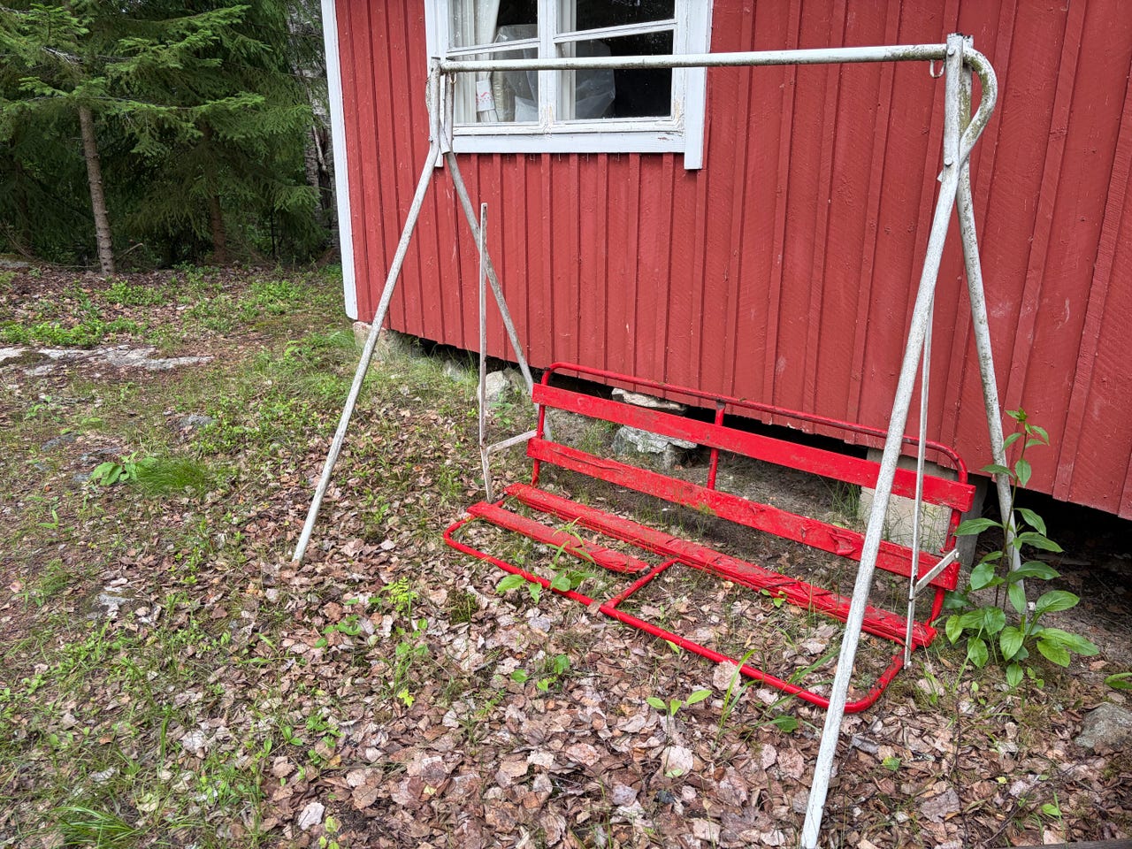 Punainen metallinen pihakeinu