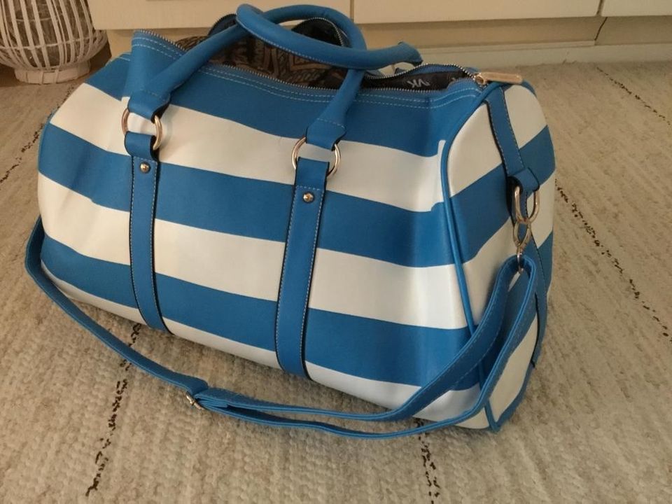 Sinivalkoinen tilava laukku