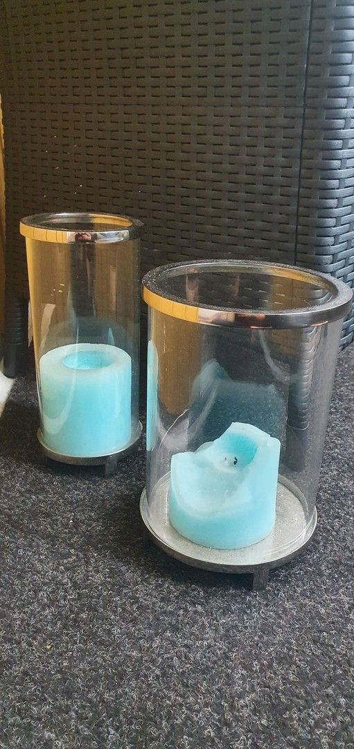 2 eri kokoista lasista kynttiläjalkaa