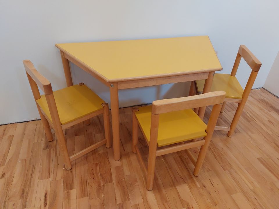 Lasten keltainen pöytä ja kolme tuolia