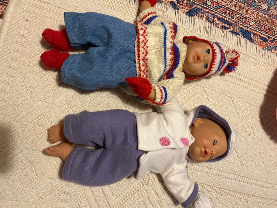 Kaksi nukkea, turvaistuin ja kori nuken vaatteita