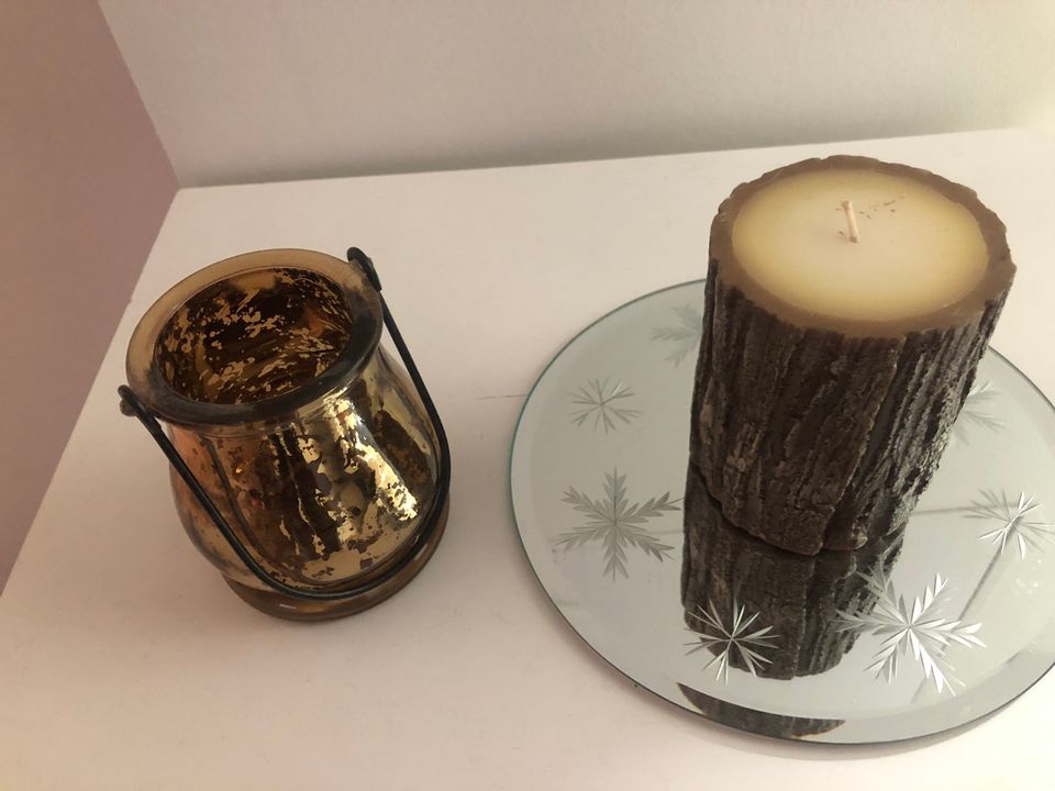 Kynttilä peilialustalla ja tuoksukynttilät lasiastiassa