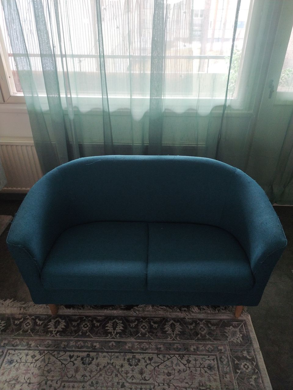 Petroolin värinen sohva