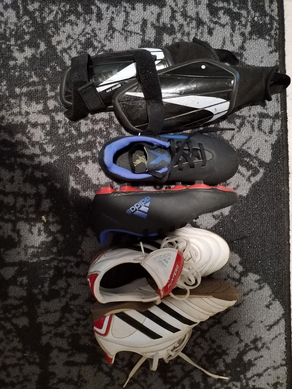 Jalkapalloon kahdet kengät sekä säärisuojat