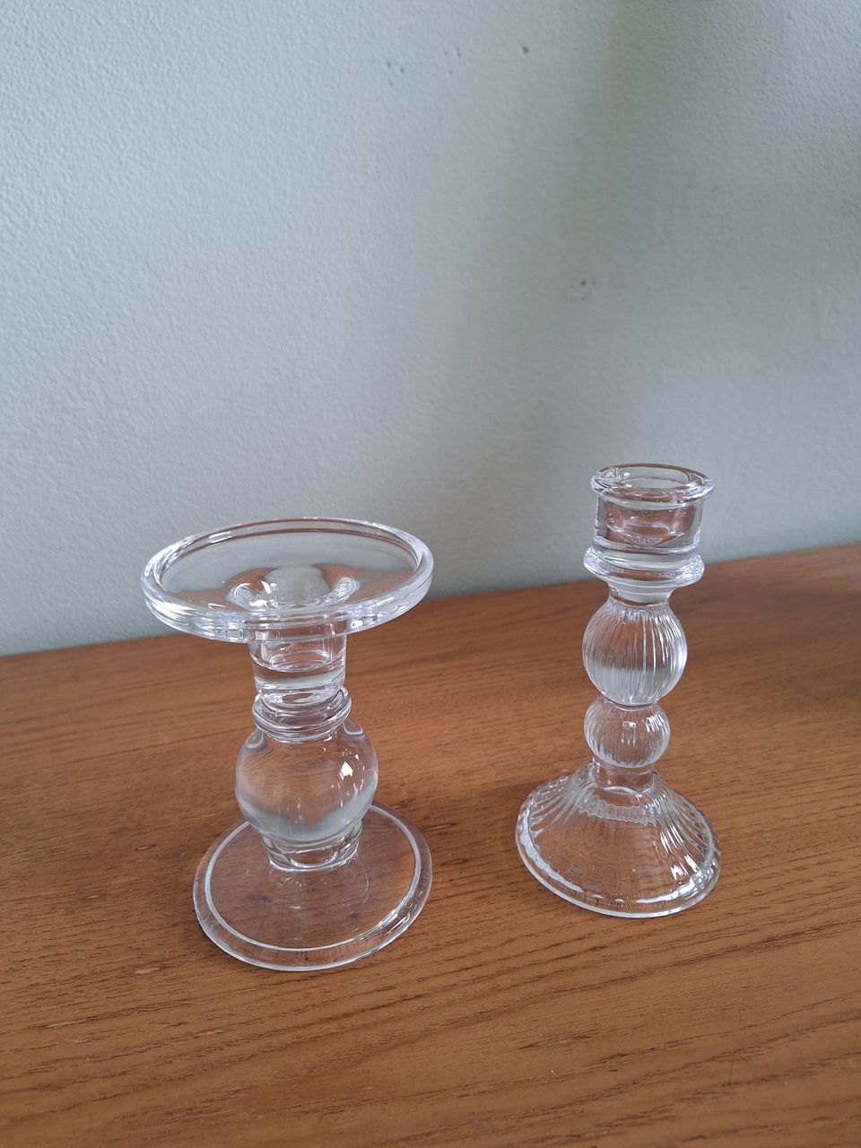Kaksi lasista kynttilänjalkaa
