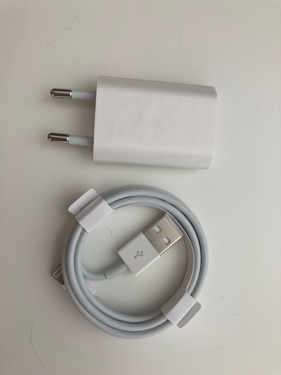 Uusi Apple Lightning–USB-johto ja laturin pää