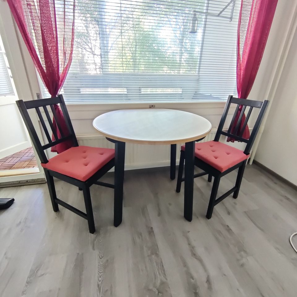 Pyöreä pöytä ja kaksi tuolia