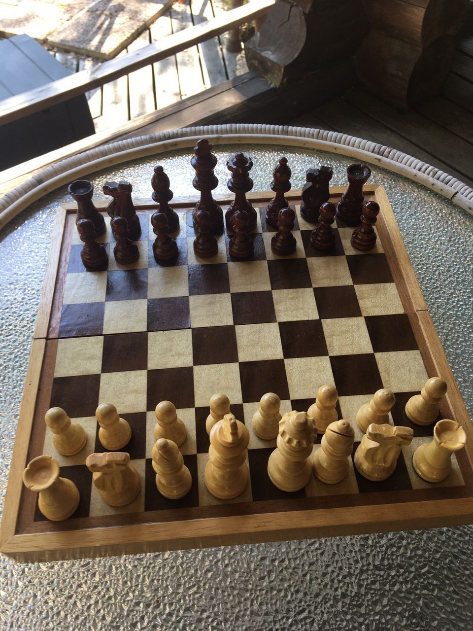 Puinen shakkipöytä nappuloineen.