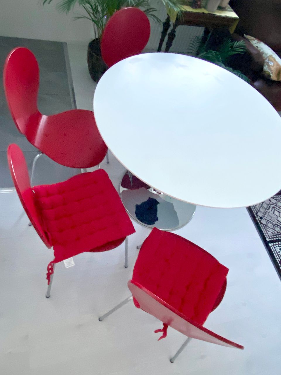 Valkoinen pyöreä pöytä ja 4 punaista tuolia