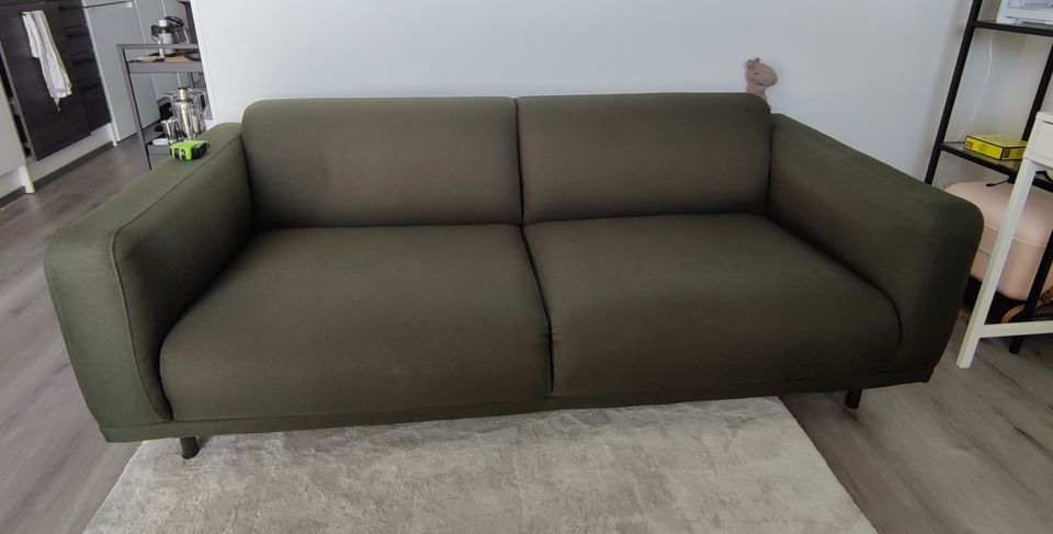 Tummanvihreä sohva