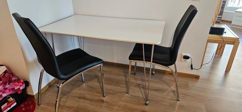 Valkoinen ruokapöytä (JYSK) ja kaksi mustaa tuolia