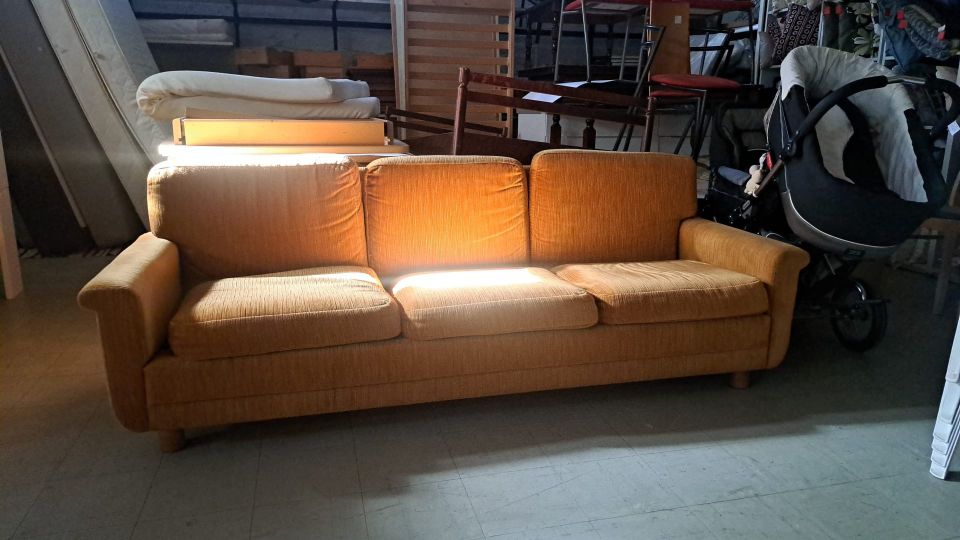 Kellertävä kolmen istuttava sohva