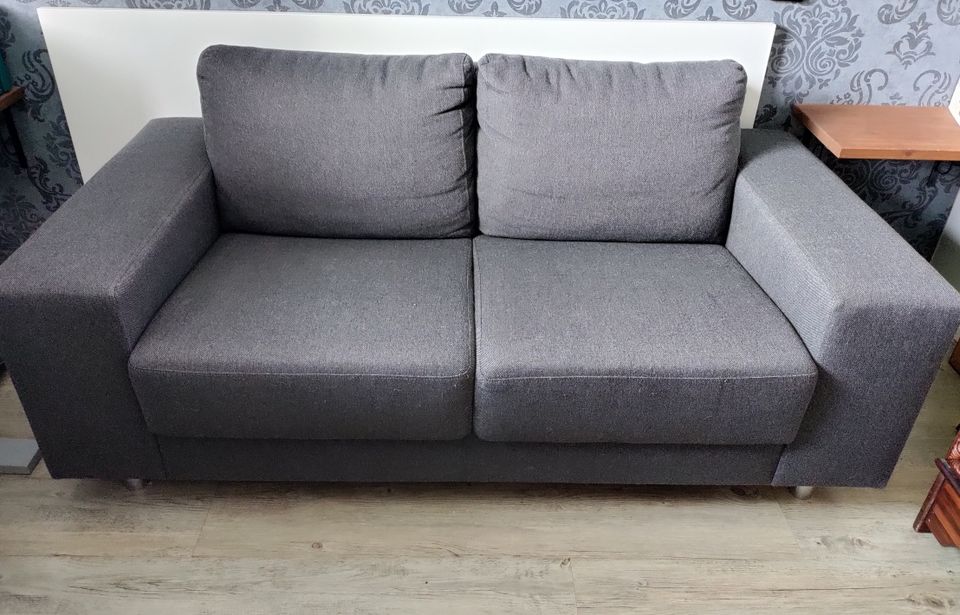 Tummanharmaa sohva