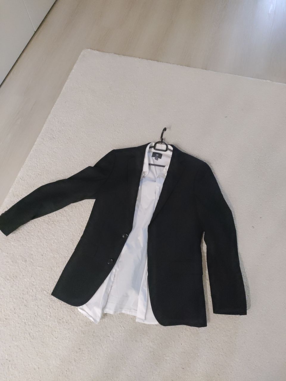 Musta puvun takki ja paita