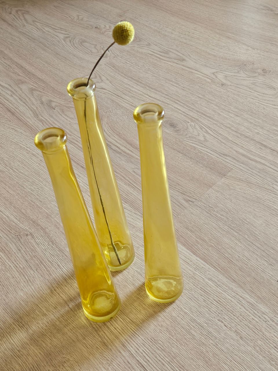 3 keltaista lasipulloa