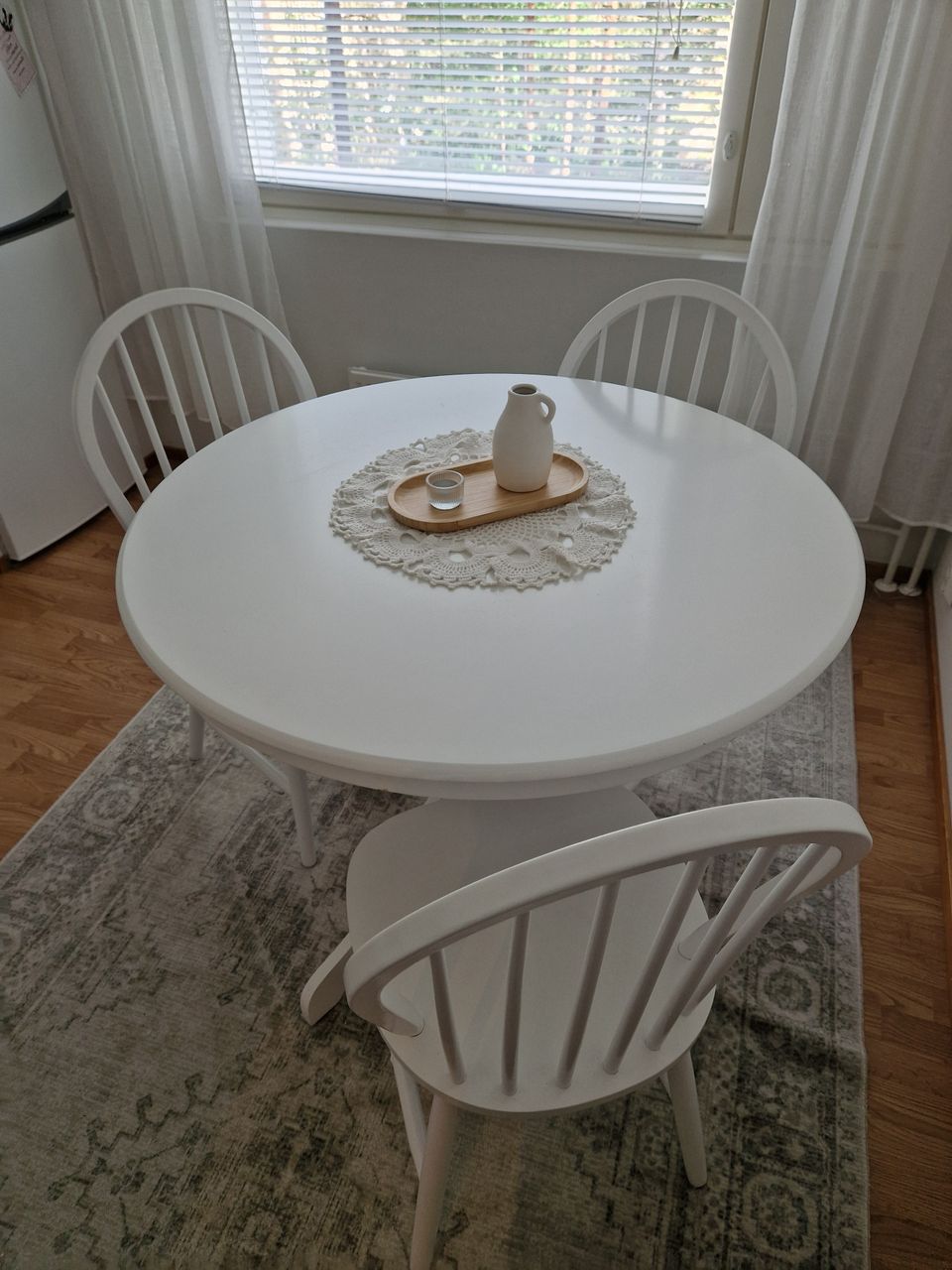 Valkoinen pyöreä ruokapöytä ja 3 valkoista pinnatuolia