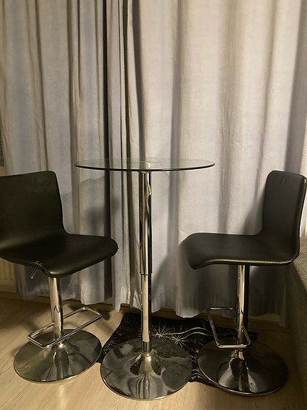 Lasinen baari pöytä ja pari baarituolia