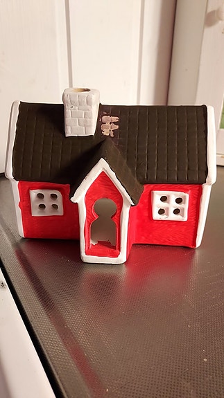 Keraaminen punainen mökki tuikkutalo