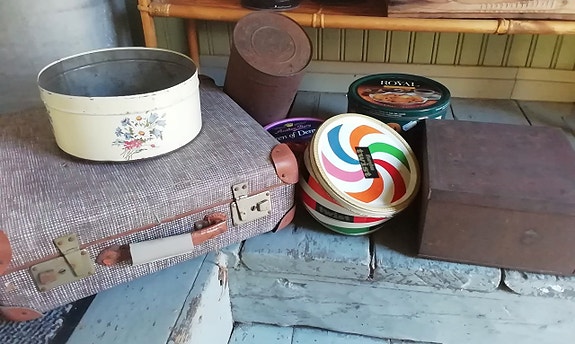 Vanhoja peltipurkkeja, salkku ja silitysrautoja