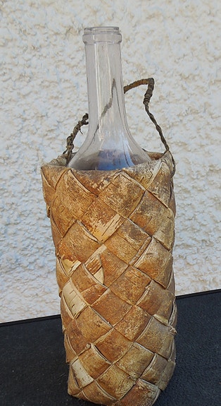 Vanha pullo tuohikorissa