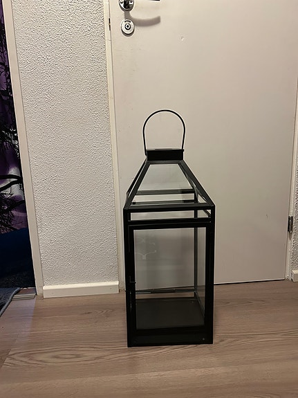 Metallinen musta lyhty lasiseinillä