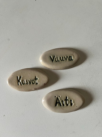 Keraamiset vauva, äiti ja kasvot kyltit