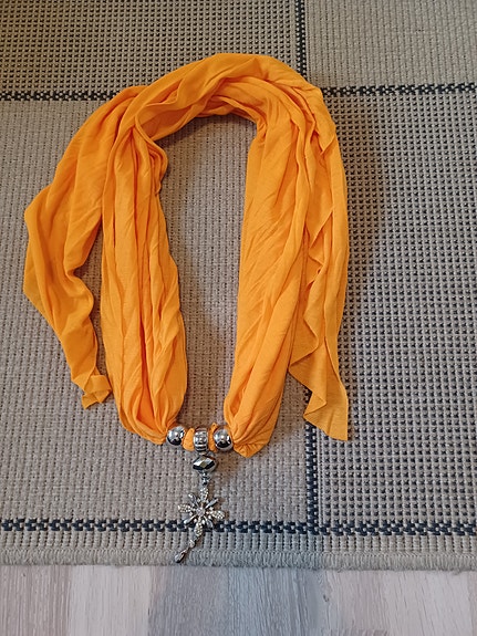 Oranssi huivi korulla.