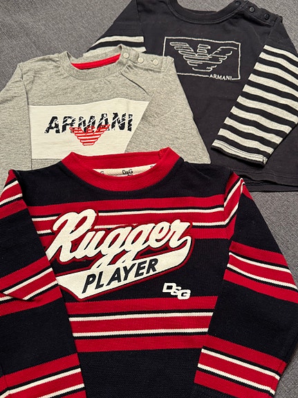 Kolme T-paitaa. Yksi "D&G JUNIOR". Kaksi "ARMANY BABY".
