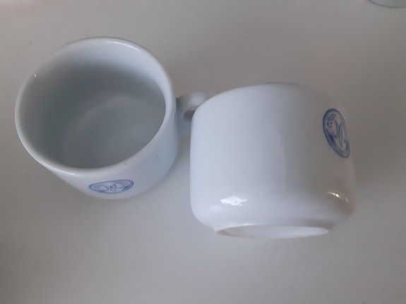 Valkoiset kahvikupit sinisellä kuviolla