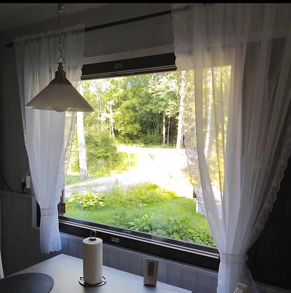 Valkoiset kevyet verhot ikkunaan