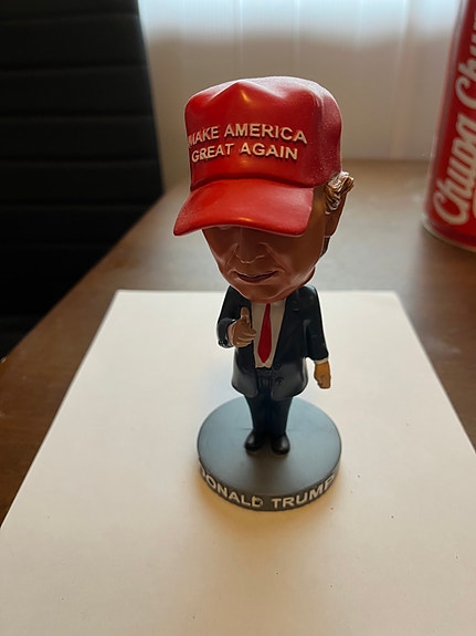 Donald Trump -aiheinen pieni patsas punaisella lippalakilla
