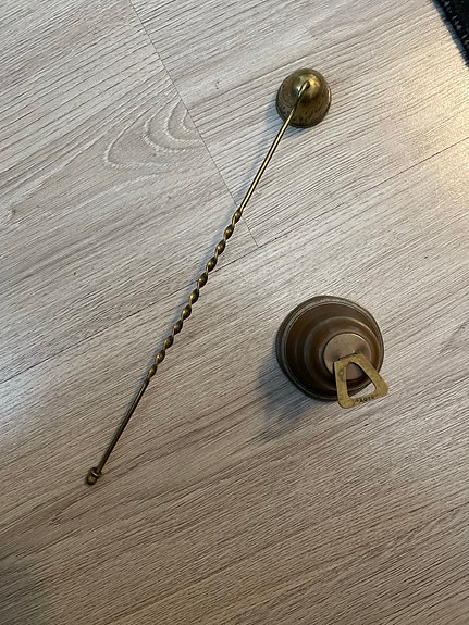 Messinkinen kynttilänsammutin ja pieni kello