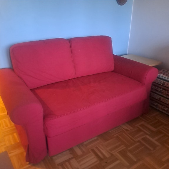 Punainen avattava vuodesohva.