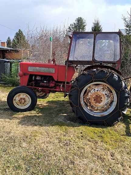 Punainen traktori ohjaamolla