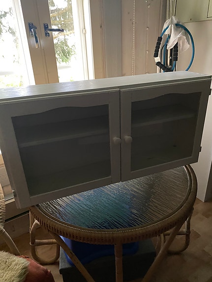 Pieni lasiovellinen kaappi seinälle