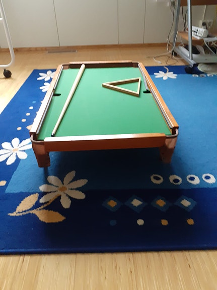 Pieni biljardipöytä, biljardikeppi ja kolmikulmio