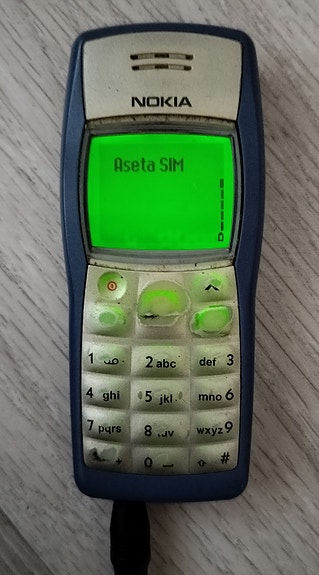 Nokia 1100 puhelin ja laturi