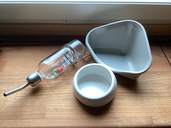 Jyrsijän tarvikkeita; juomapullo, ruoka-astia ja WC