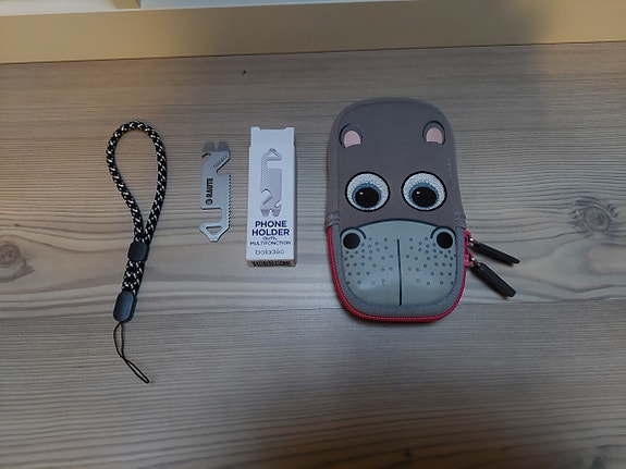 Pieni kännykkäpussi, phone holder ja puhelin käsilenkki.