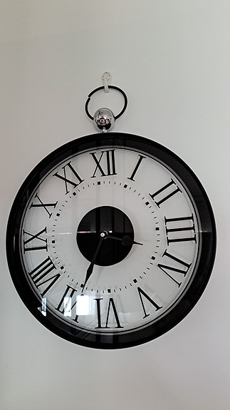 Musta seinäkello roomalaisilla numeroilla