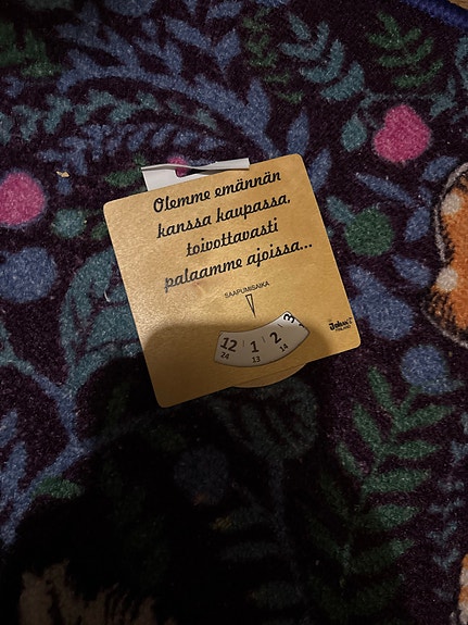 Emännän kanssa kaupassa -puinen ovikyltti kellolla