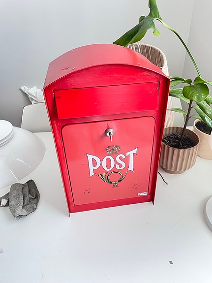 Punainen metallinen vintage postilaatikko POST logolla