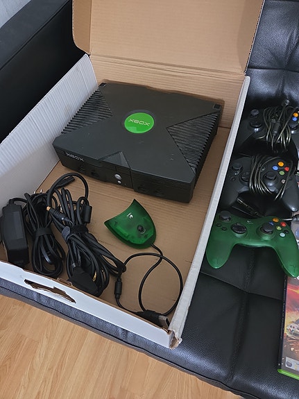 Microsoft Xbox konsoli ohjaimilla ja peleillä