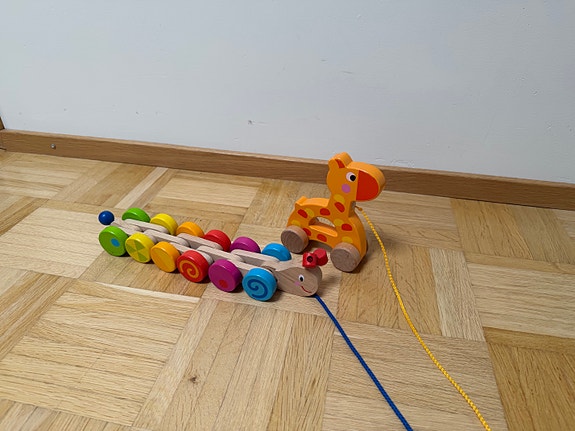 Taaperolle puinen vedettävä lelu, kirahvi ja värikäs matolelu