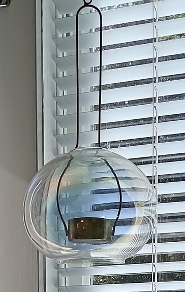 Pallonmuotoinen, ripustettava tuikkulyhty ikkunaan