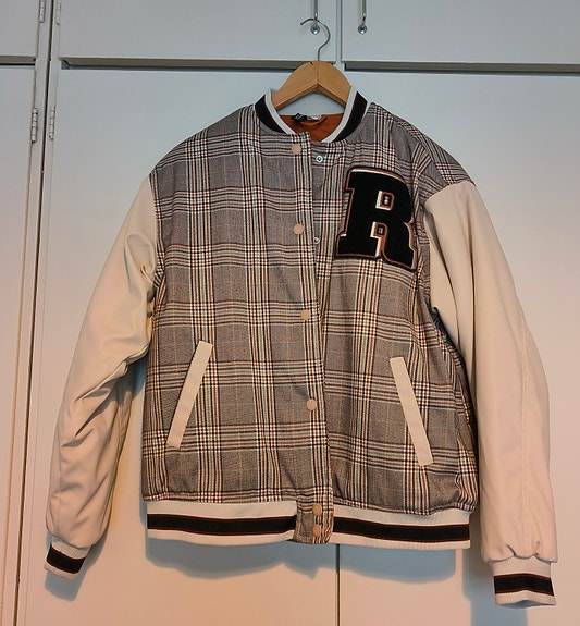 Beigenvärinen collegetakki tai baseball takki