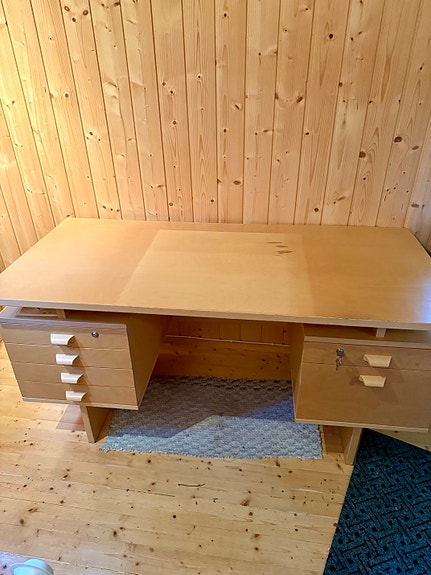 Vaalea puinen kirjoituspöytä laatikostoilla