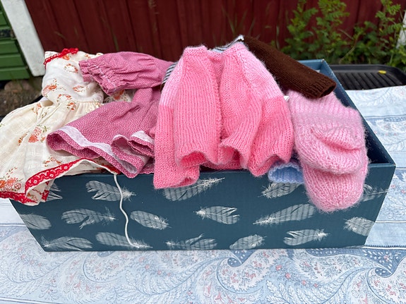 Laatikollinen nuken vaatteita